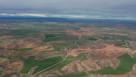 aerial-view-desert-landscape-with-a-road-and-green-fields-high-altitude-Spain